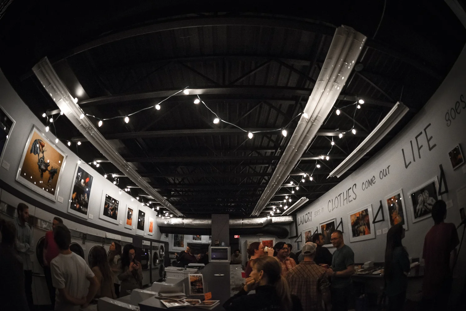wide view of the laundromat gallery with string lights
