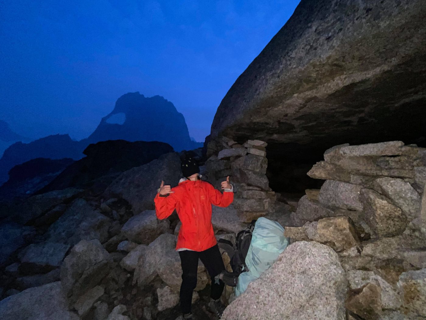 resting in a rock shelter at dusk, high in the mountains