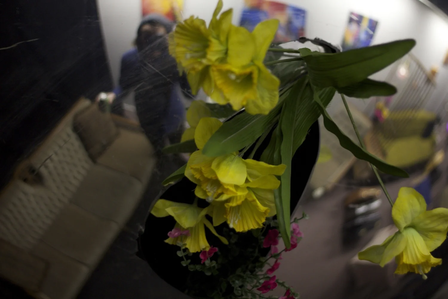 flowers reflected in the gallery window with art visible behind