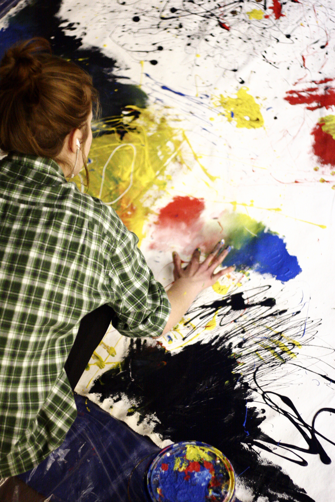 hand-painting on a large canvas on the gallery floor