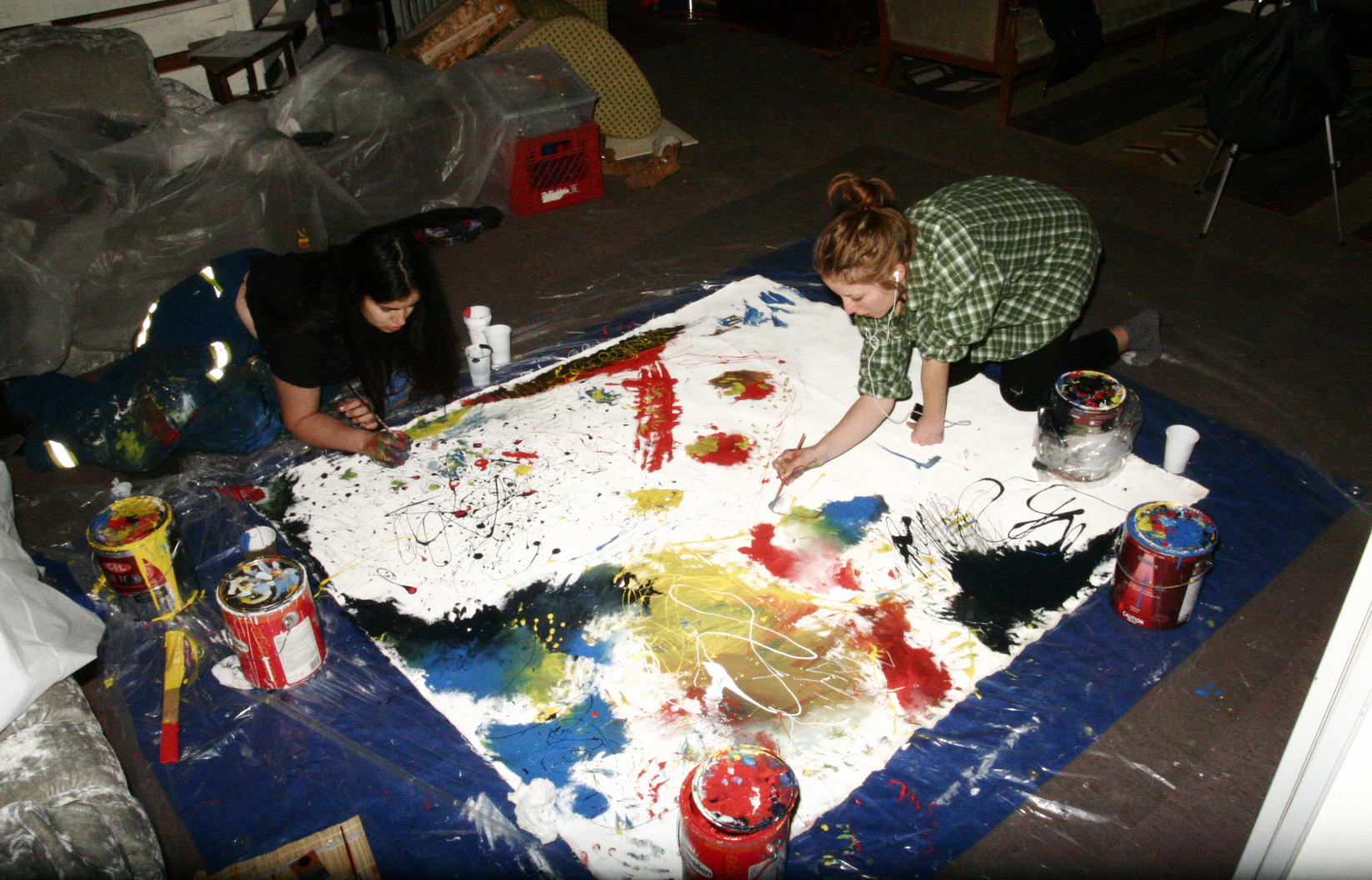 two artists painting together on the floor from above