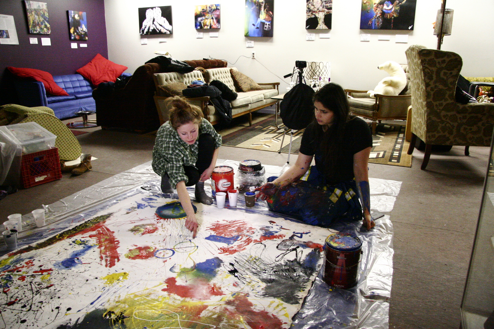 collaborative floor painting session at the gallery with art on the walls